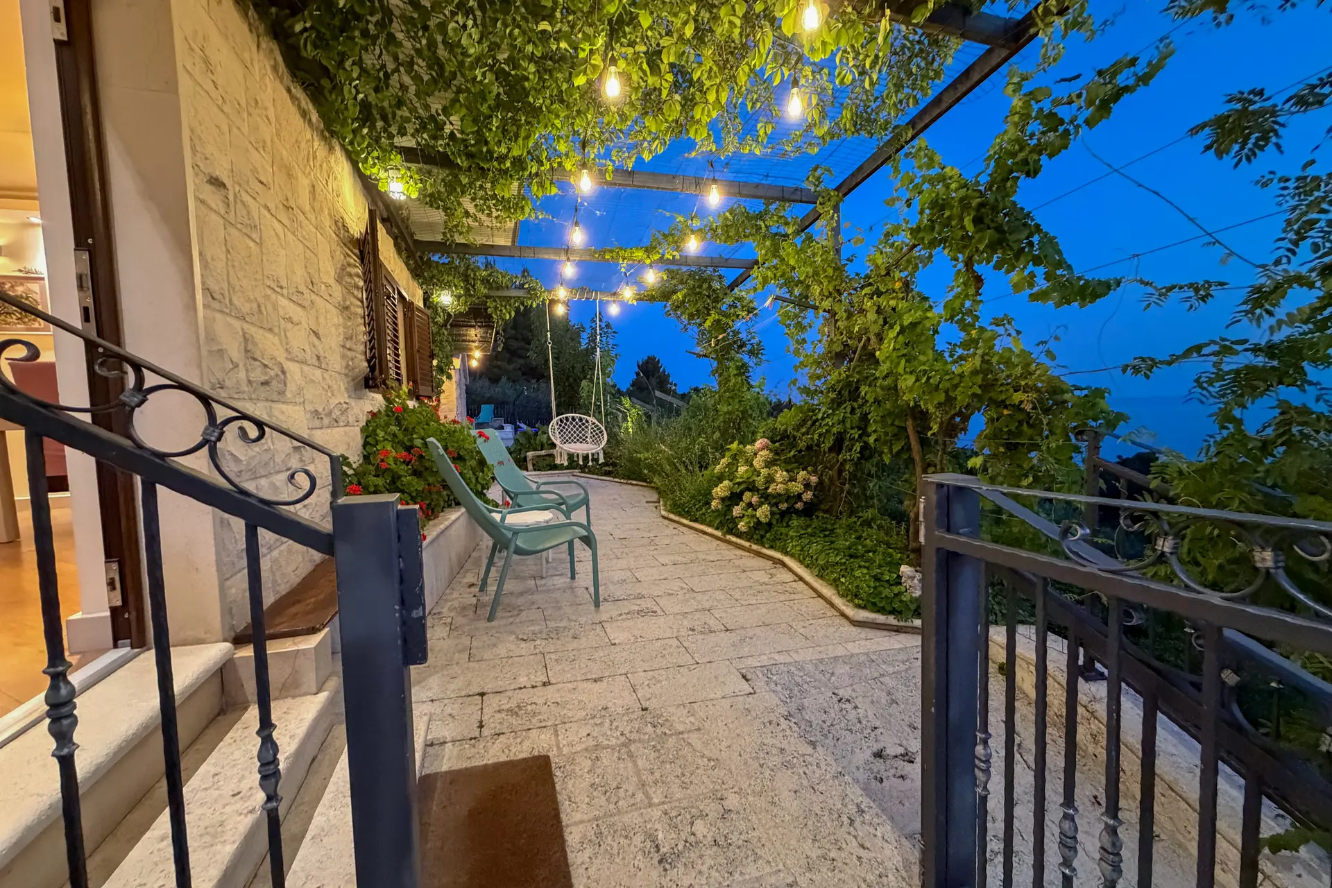 Lit courtyard and pergola at Villa Keti in the evening